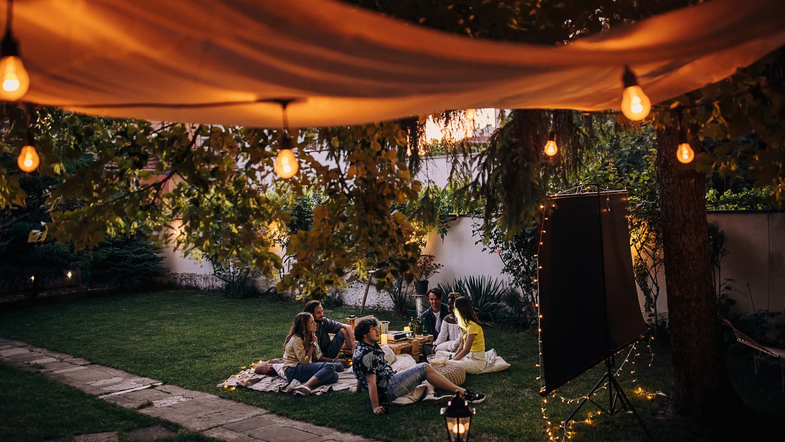 Modern backyard with smart lighting and a connected speaker near a patio seating area