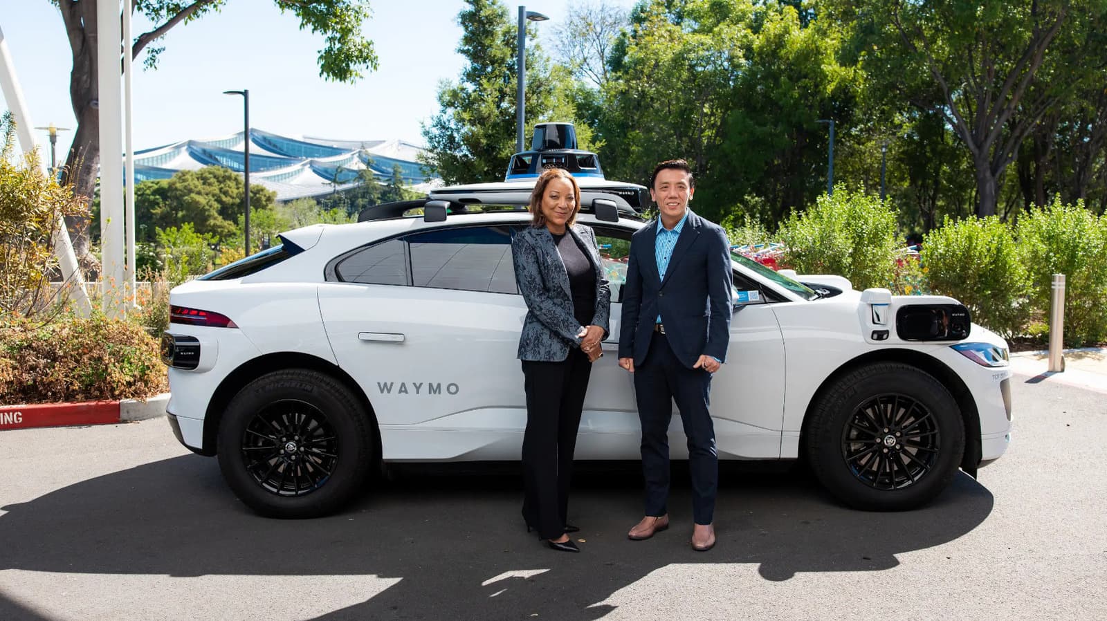 Autonomous minivan designed by Waymo navigating a tree-lined street in Singapore