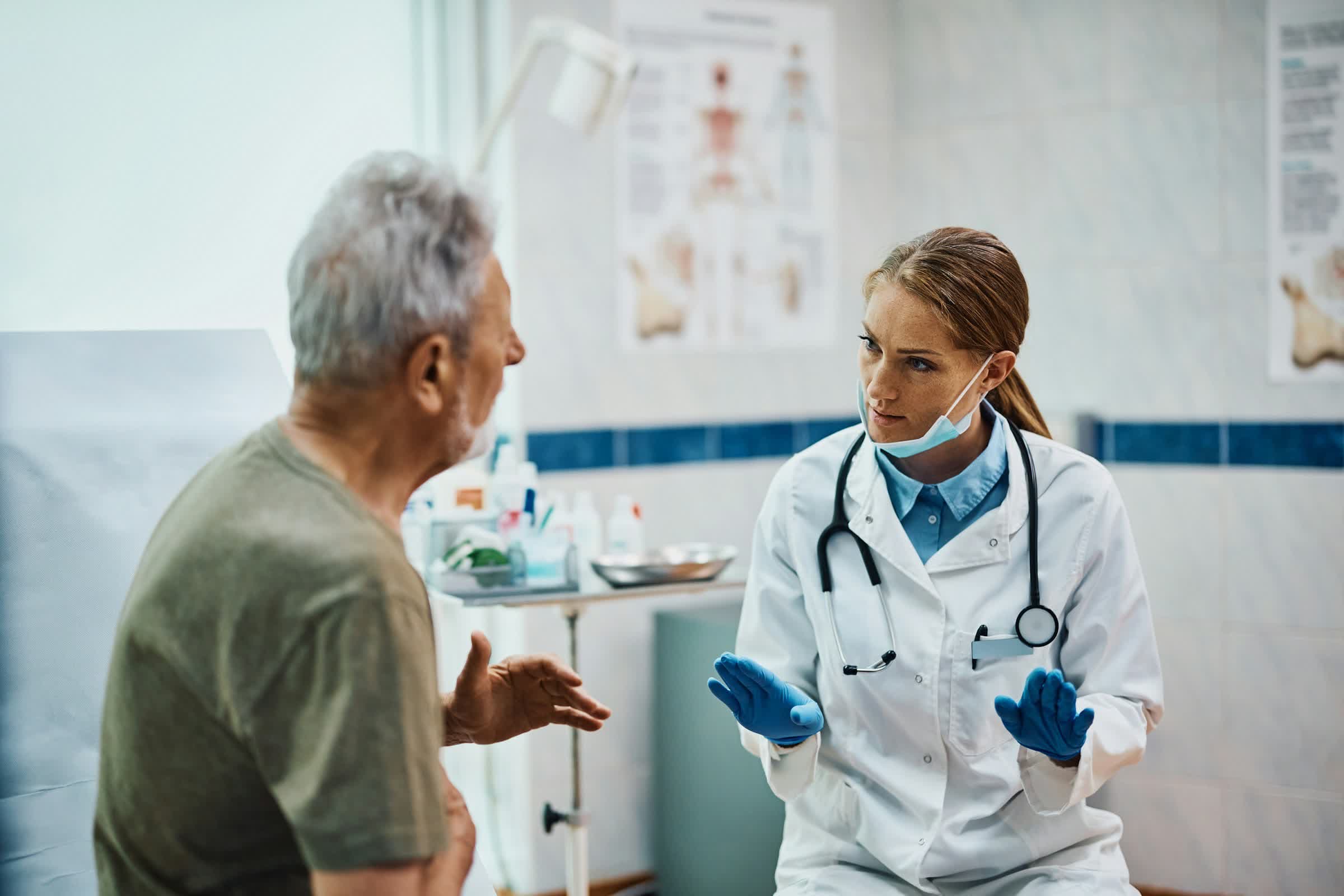 A person using a smartphone with a chatbot interface displaying medical advice while a doctor stands nearby, illustrating AI