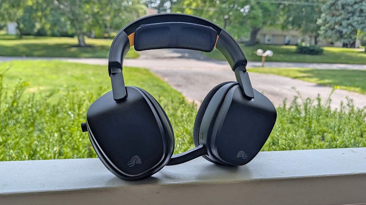 Glorious GHS Wireless InfinitePlay gaming headset sitting on a desk with a black and orange design