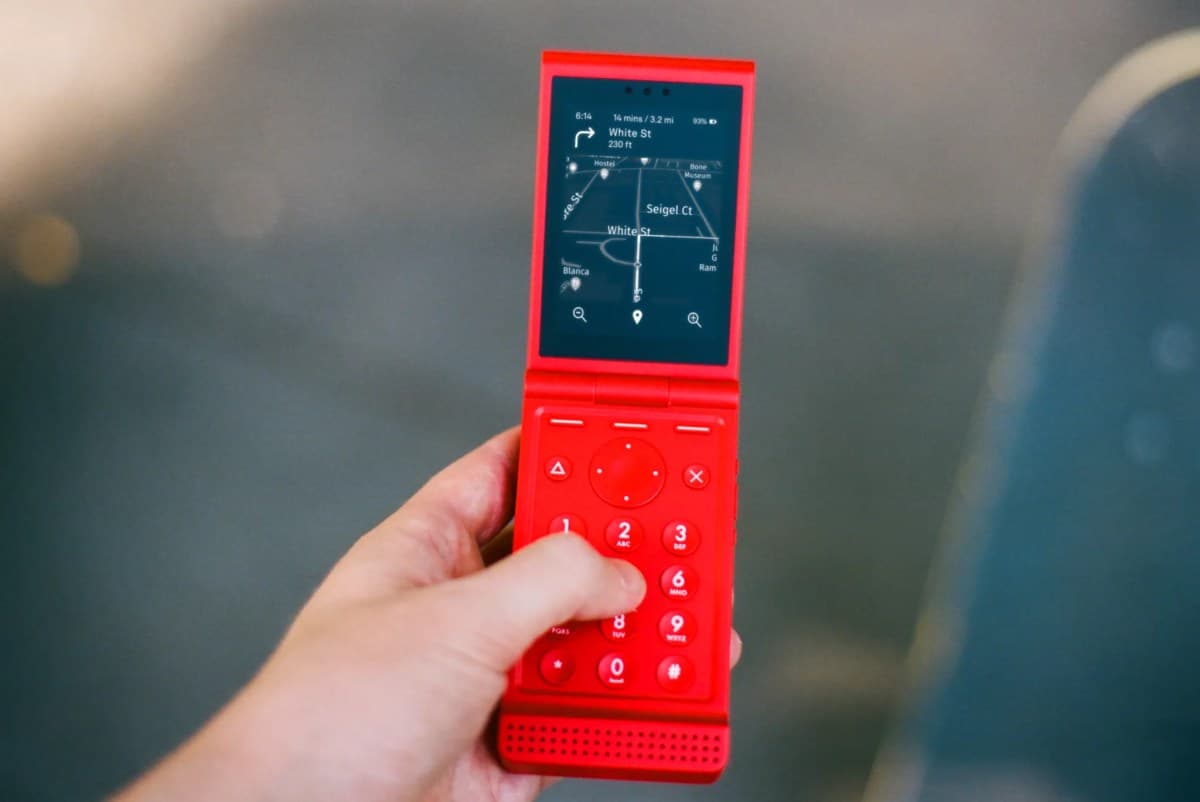 A Light Phone flip device with an e-ink display, minimalist design, and a focus on essential communication functions.
