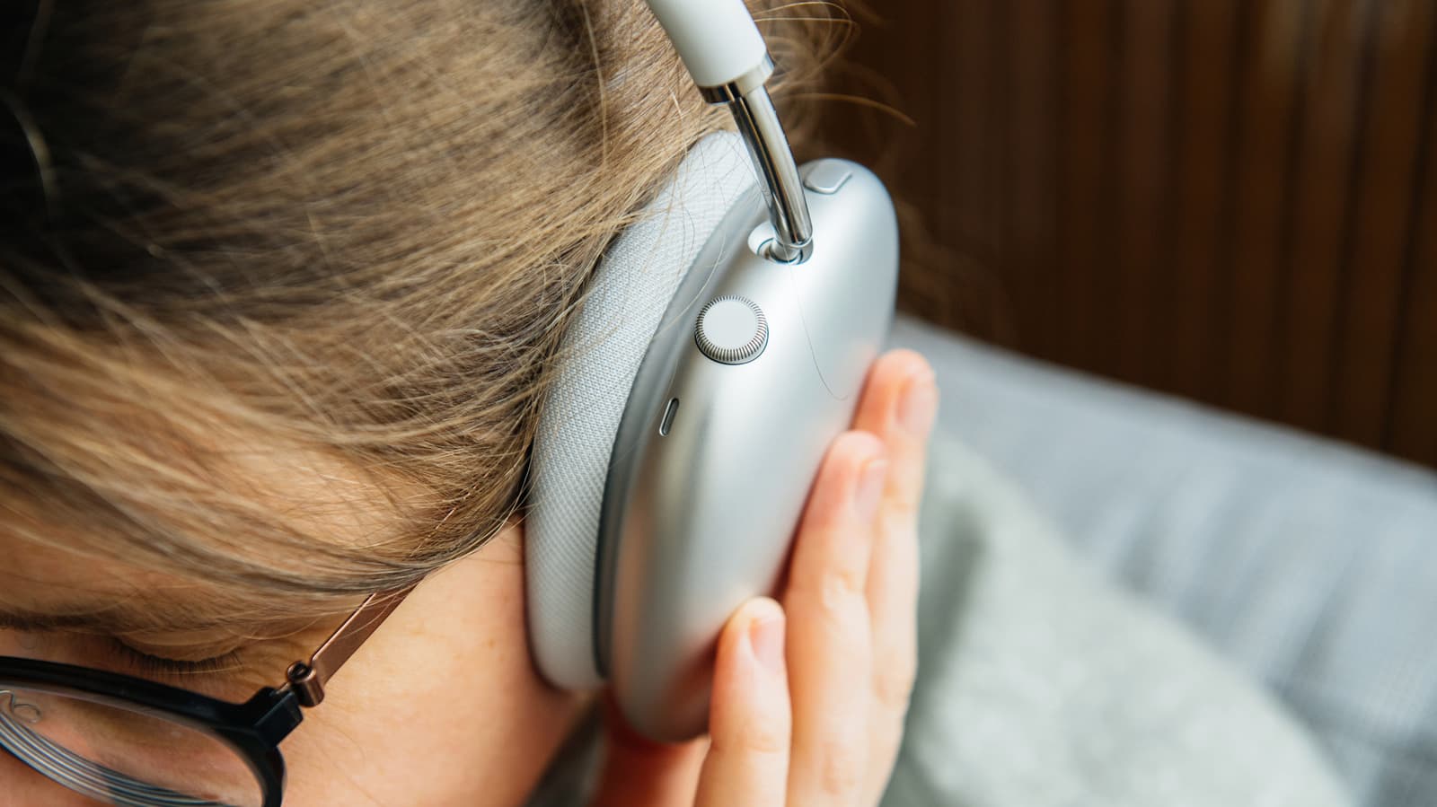 Person wearing noise cancelling headphones in a busy environment, illustrating active noise cancellation technology