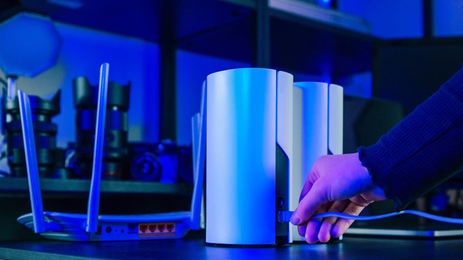 A mesh Wi-Fi system with three white nodes placed in a modern living room