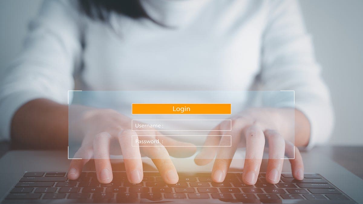 A person using a password manager app on a smartphone with a lock icon overlay representing digital security.