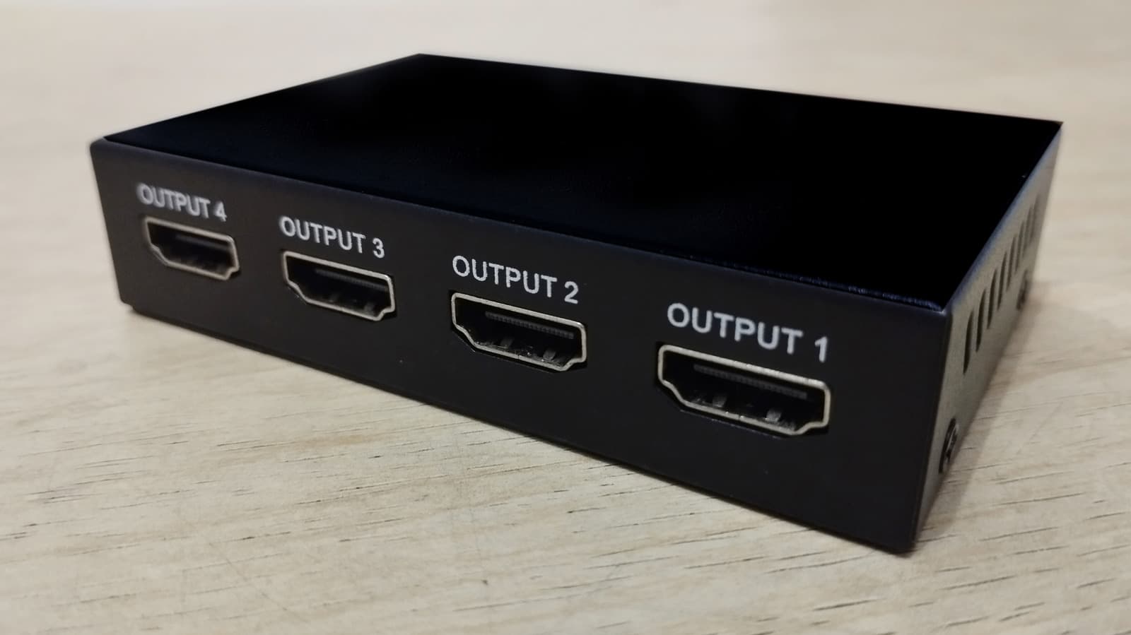 An HDMI splitter device with cables connected to multiple displays