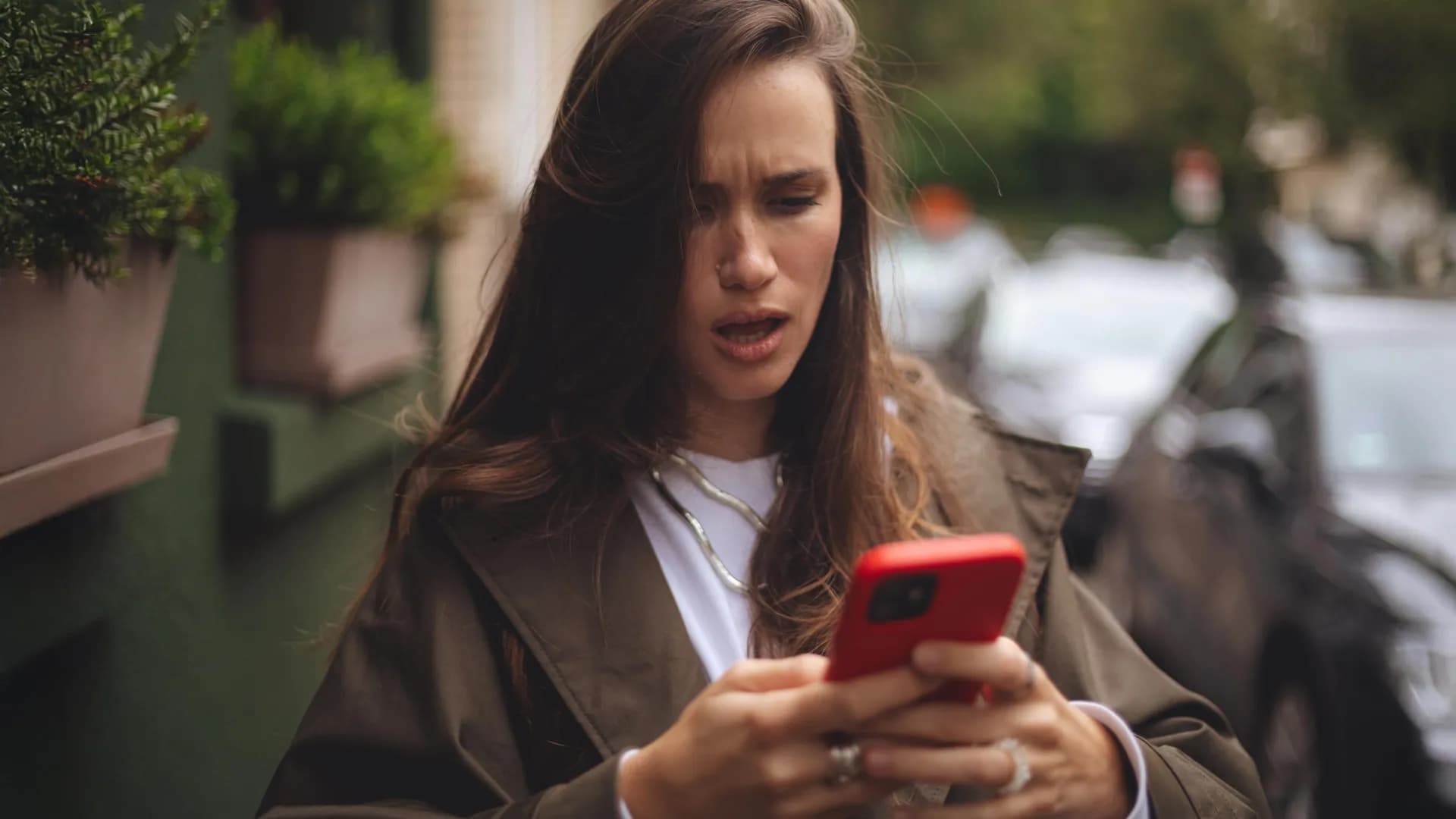 Person scrolling on smartphone with worried expression surrounded by news headlines