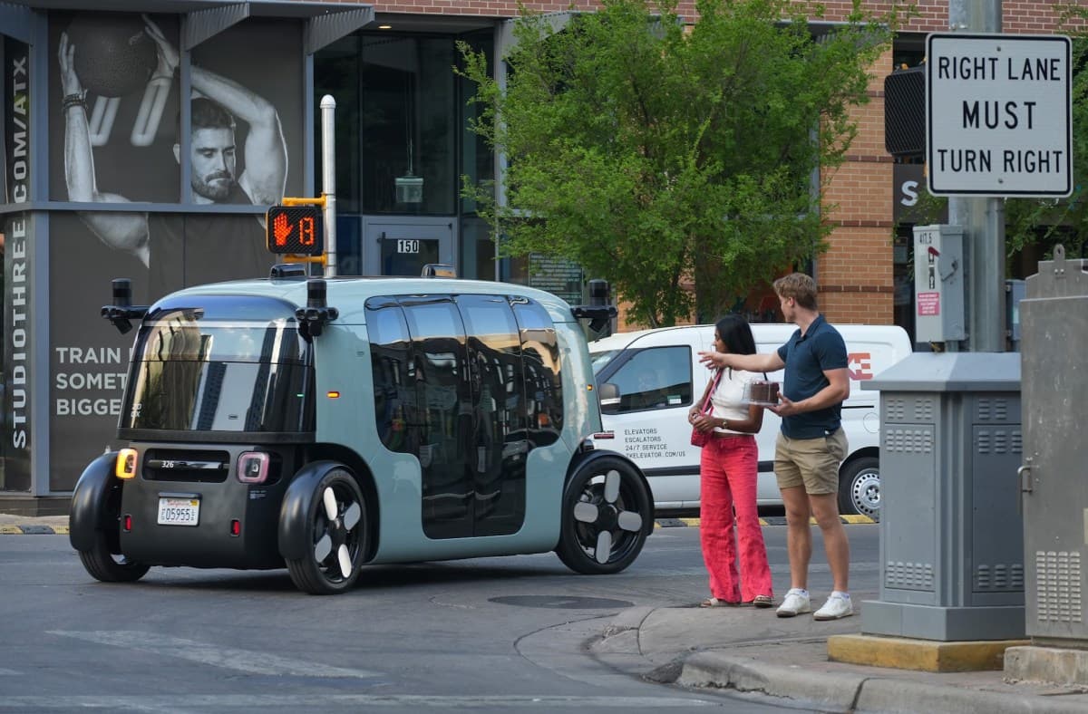Autonomous electric taxi driving through a city street at dusk with no human driver