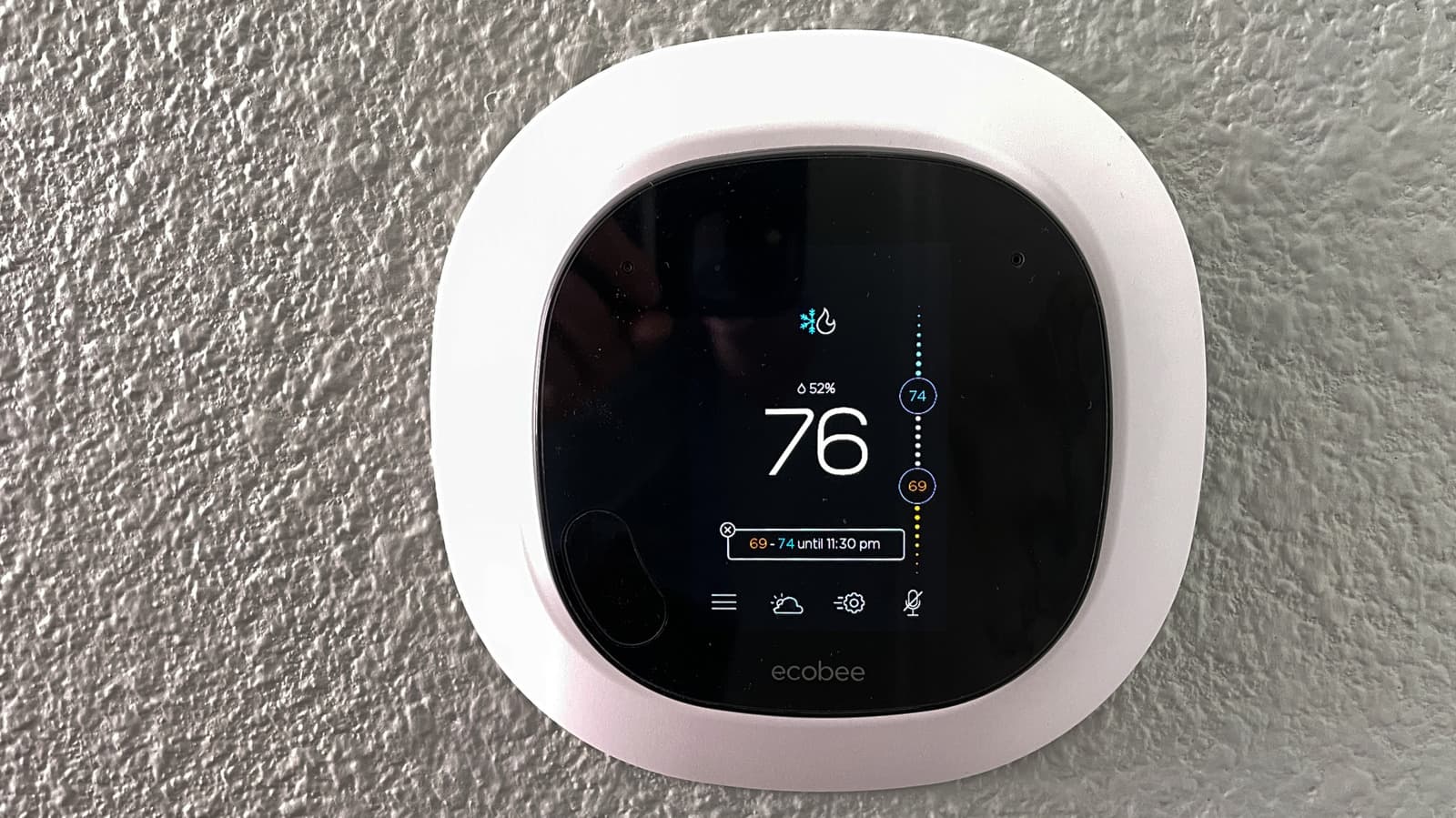 Ecobee smart thermostat mounted on a wall in a modern home interior