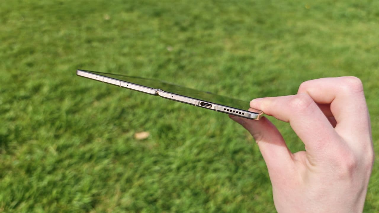 Honor Magic V6 foldable phone held outdoors showing its slim design and display