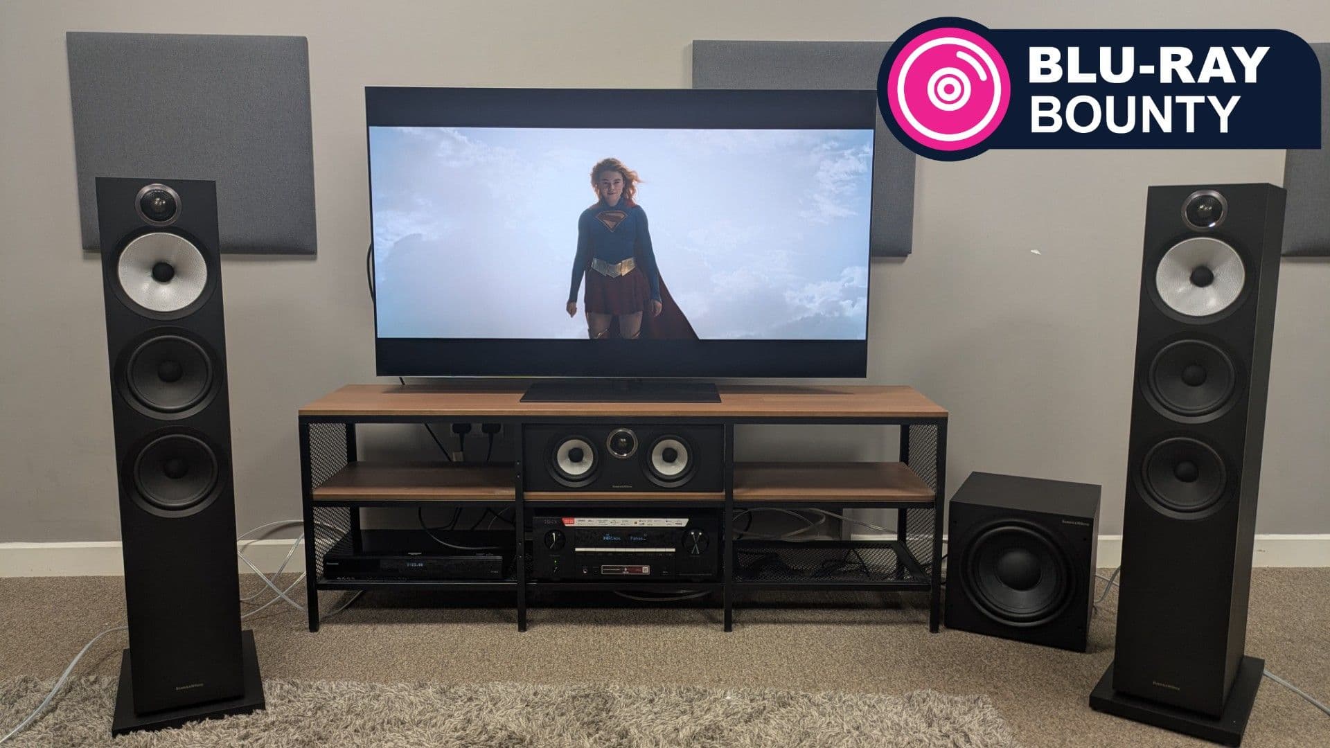 4K Blu-ray disc of Supergirl displayed on LG G6 OLED TV with home theater speakers