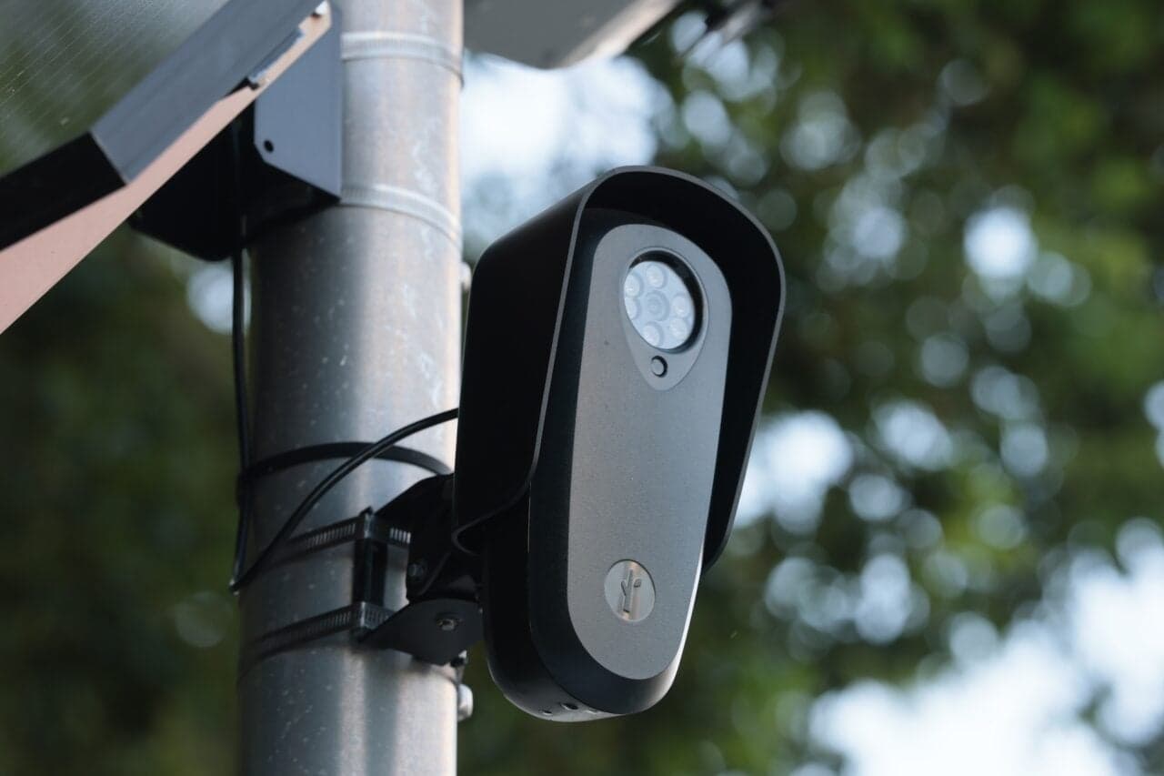 A Flock automated license plate reader camera mounted on a pole, used for surveillance by law enforcement