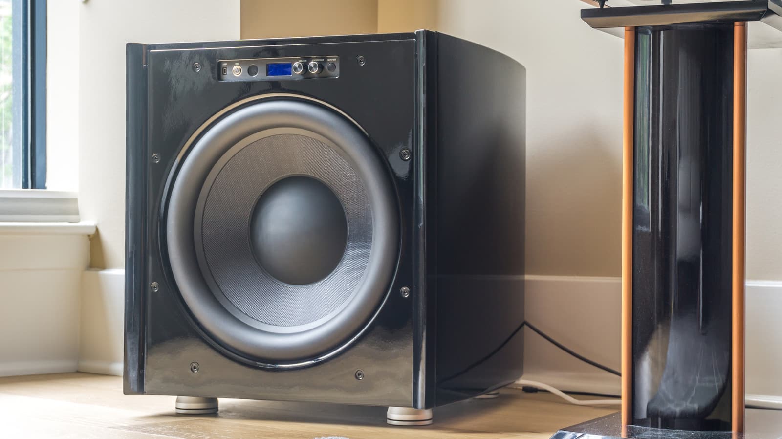 Subwoofer positioned in a corner of a living room near furniture showing typical placement error
