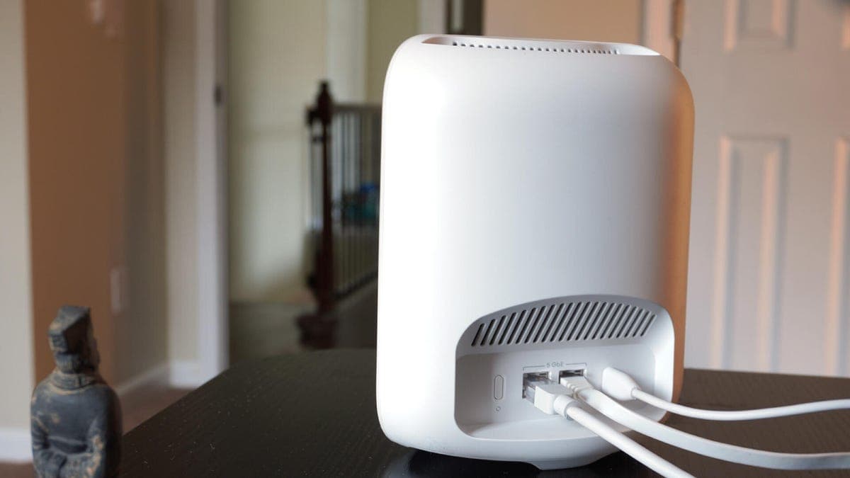 A Wi-Fi 7 router in a modern living room connected to multiple devices like laptops and smartphones