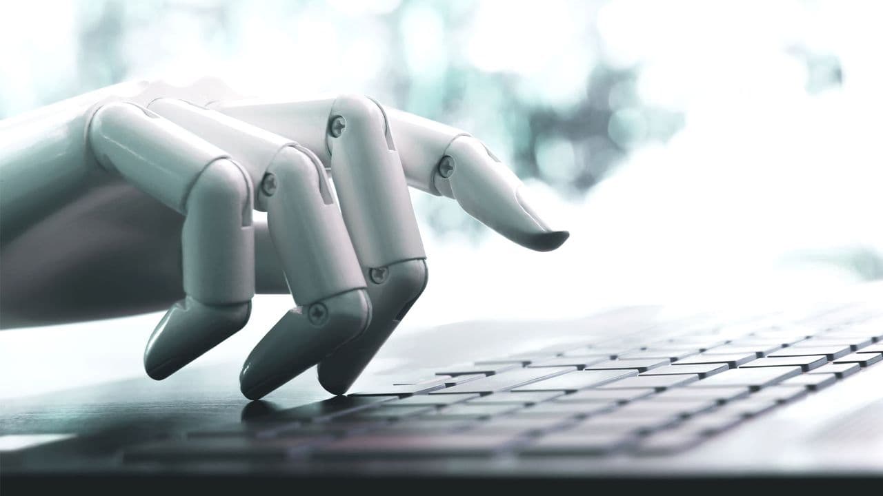 Person typing on a laptop with a glowing AI icon overlay, representing human-AI writing tension