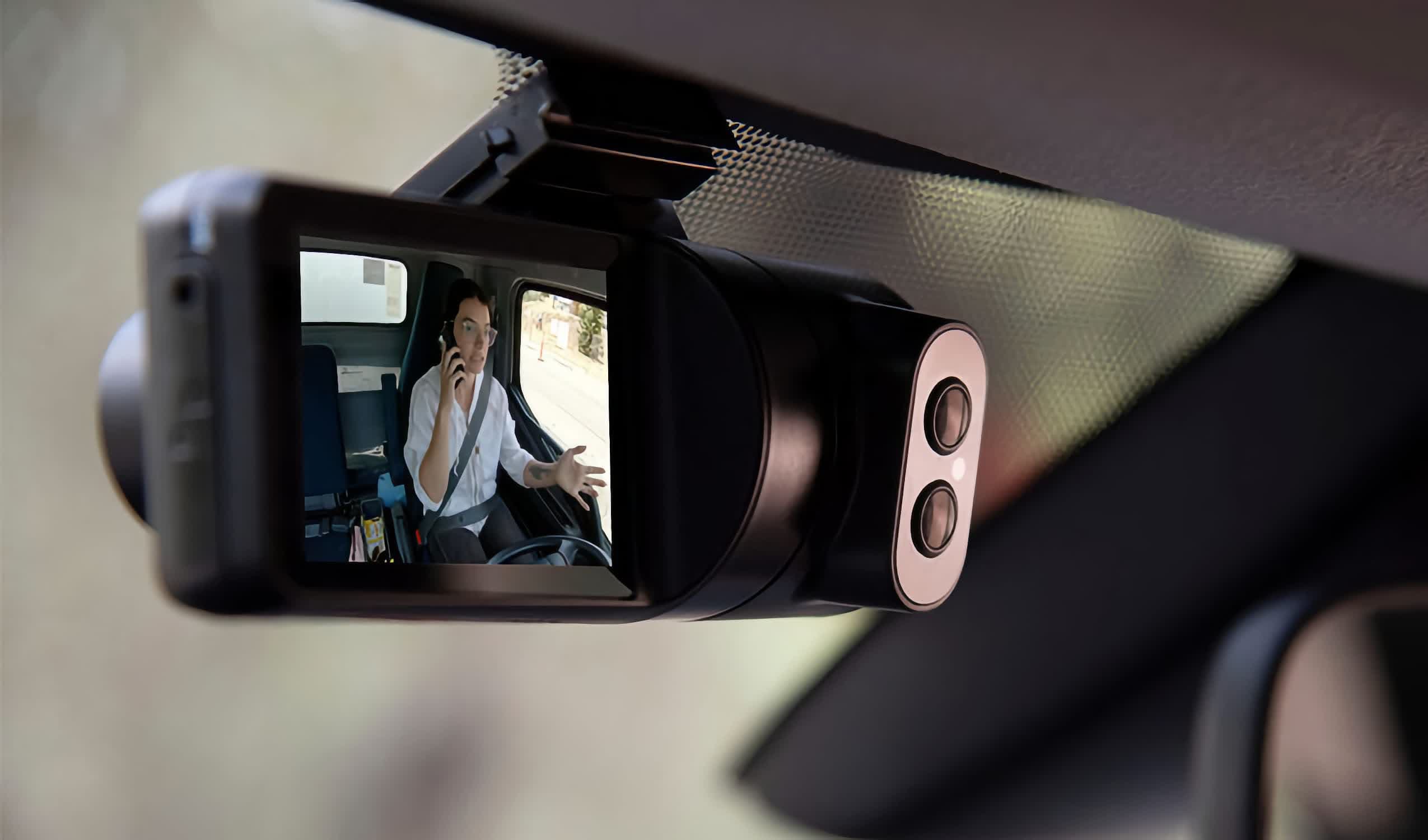 Dashboard of a car with a small hidden camera lens integrated into the interior panel near the steering wheel