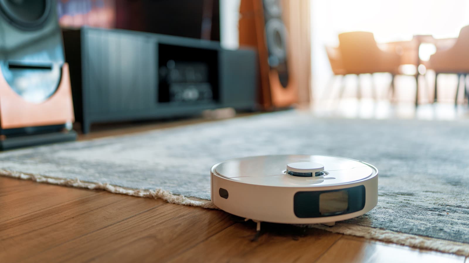 A robot vacuum cleaning a living room floor near furniture, illustrating smart home mapping and data collection concerns