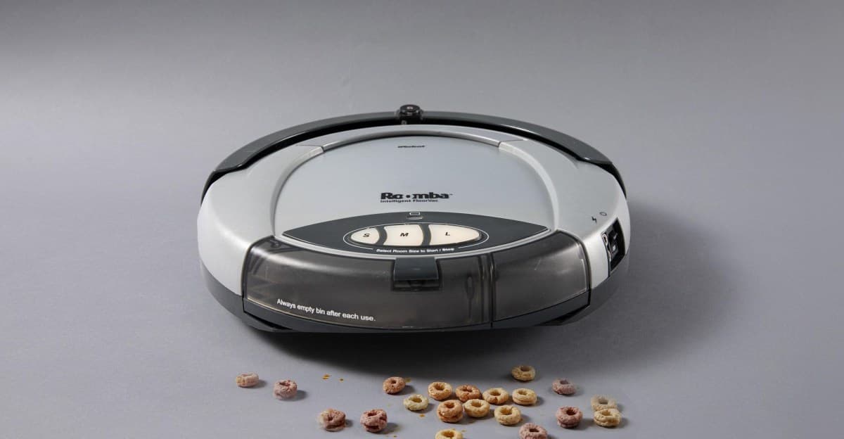 A robot vacuum cleaning cereal off a kitchen floor