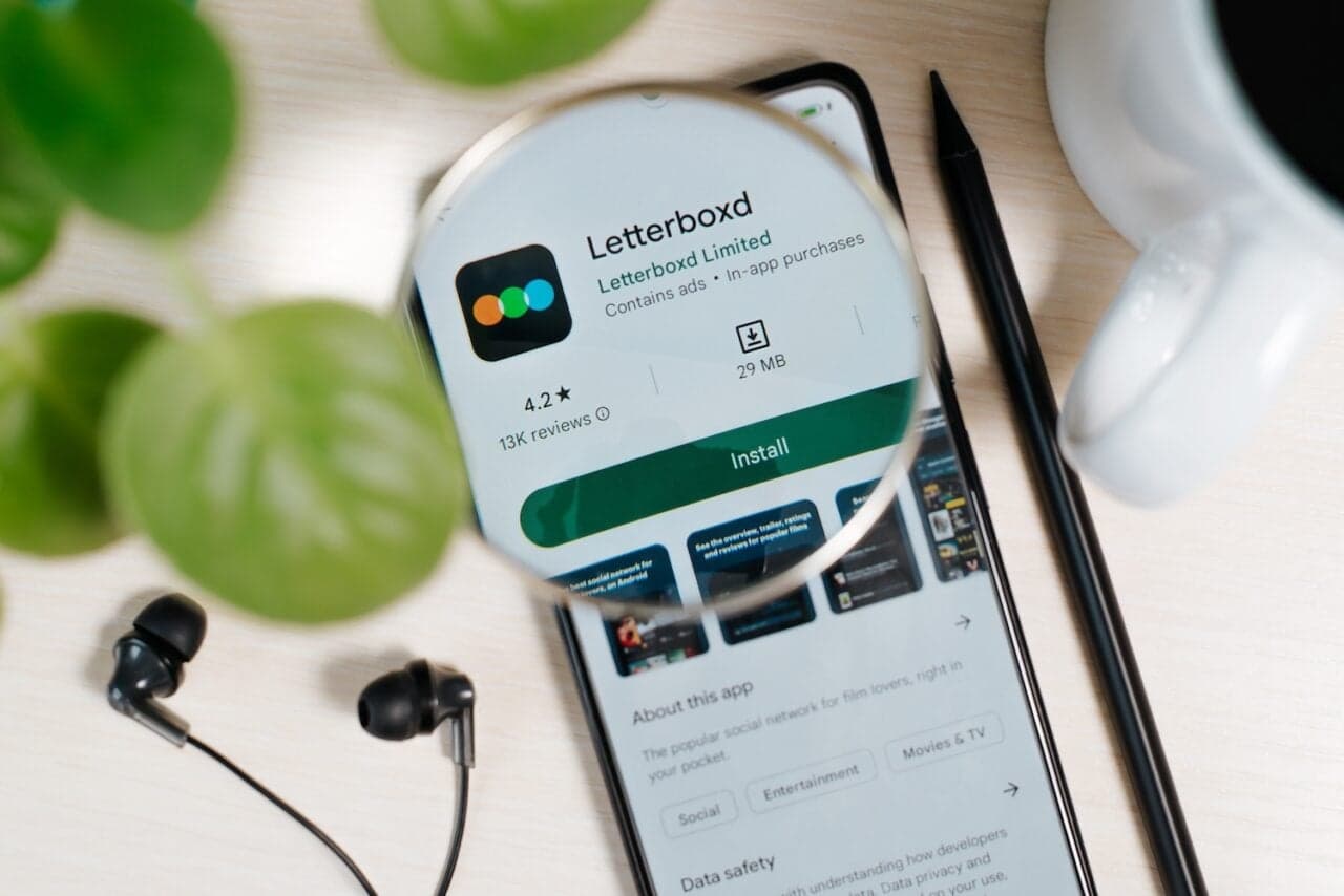 Letterboxd logo displayed on a smartphone showing movie ratings and reviews.