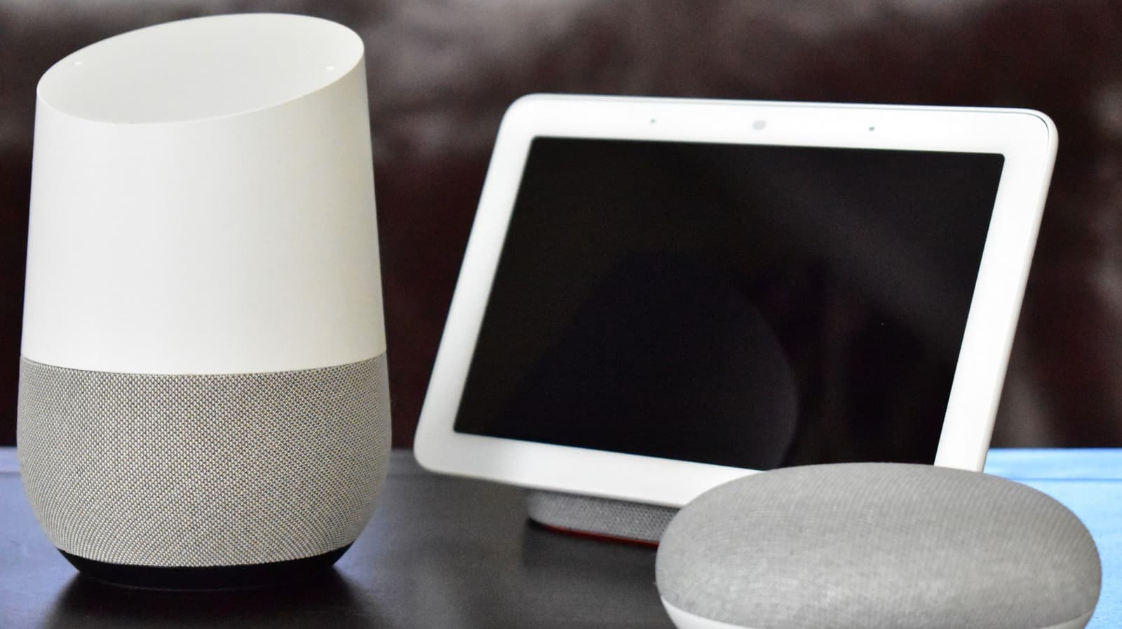 A person speaking to a smart speaker with a retro video game controller nearby