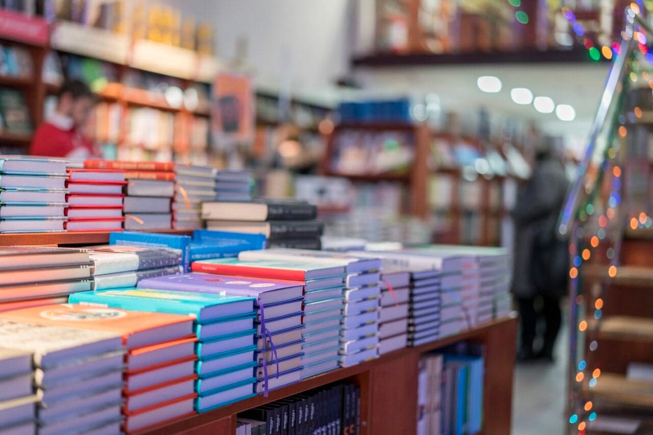 A stack of books with AI-generated cover art showing unnatural patterns and typography errors