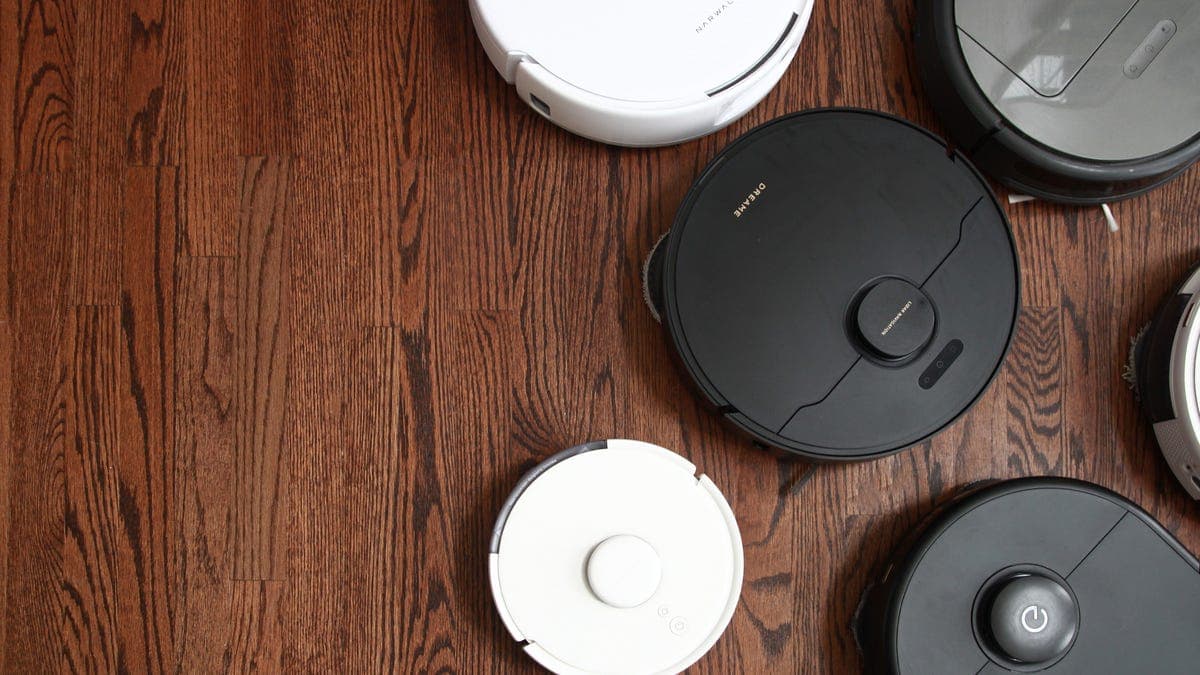A robot vacuum mop cleaning a hardwood floor in a modern living room with furniture