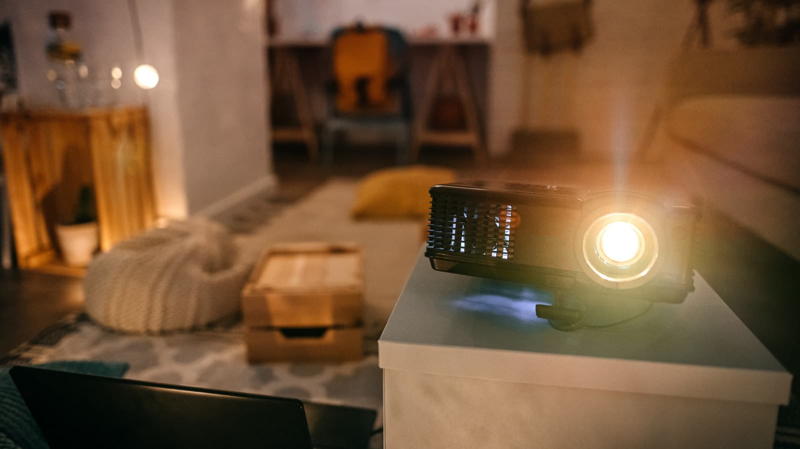 A budget projector displaying a dim and washed-out image on a wall in a dimly lit room